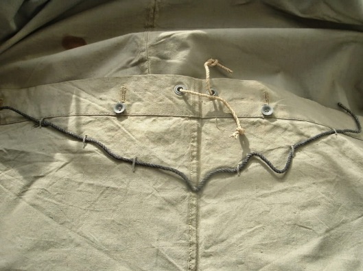 Detail with cord used when the Zeltbahn was used as a poncho. The "Zeltleine 92" was 2 meters long, the "Halsleine 92" (the shorter one if you carry it as poncho) was 90cm long.