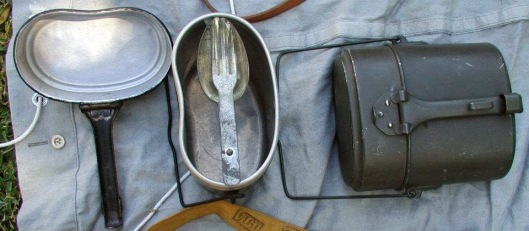 The spork in its resting place in the mess kit. This particular mess kit is an infantry pattern which is readily identified by the loop on the handle that allows a strap to pass through, which attached it to the soldier's knapsack. 
